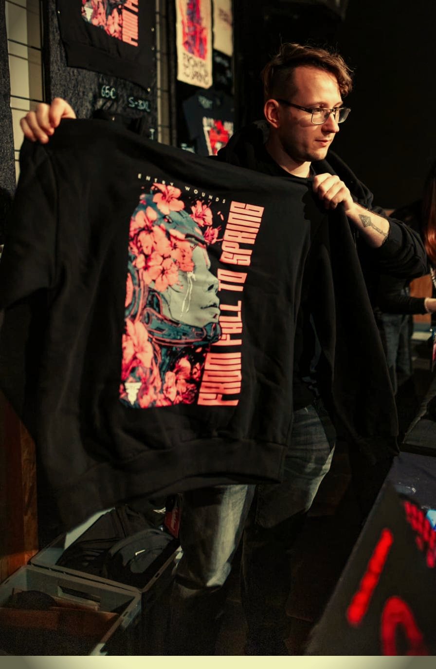 Leon präsentiert ein Bandshirt am Merchstand